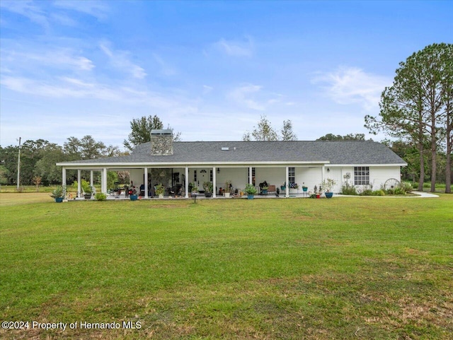 rear view of property featuring a yard and a patio area