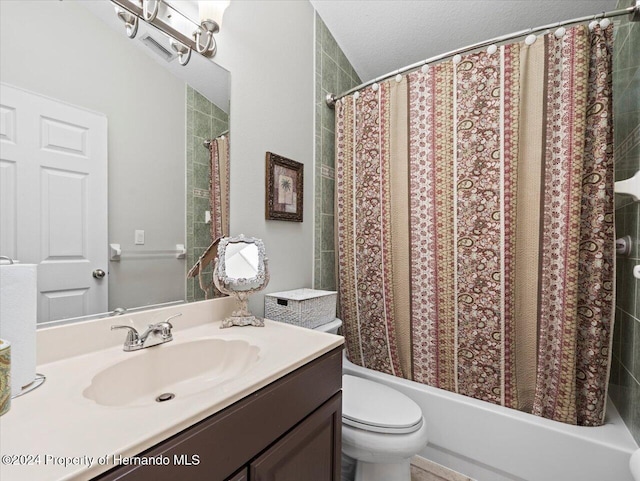 bathroom with vanity, toilet, and a textured ceiling