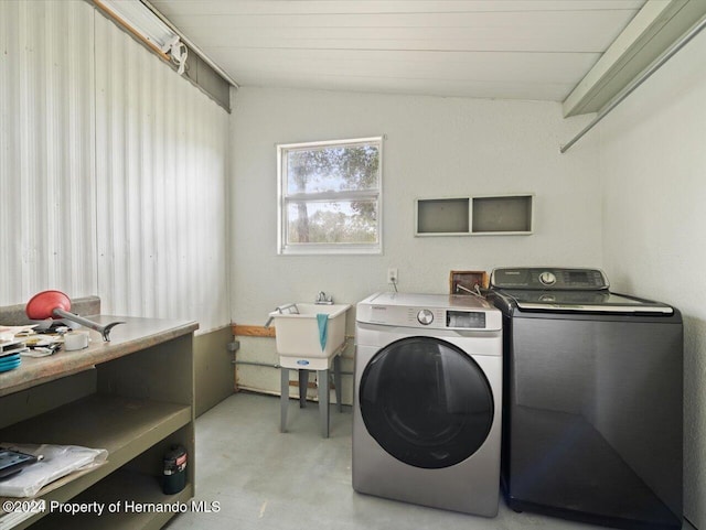 clothes washing area featuring washing machine and dryer and sink