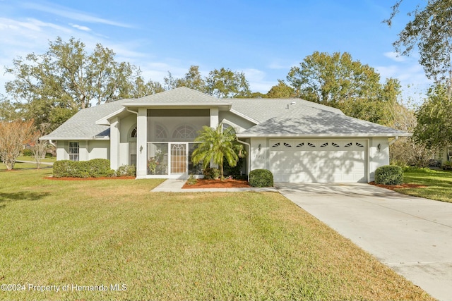 view of front of property with a garage and a front lawn