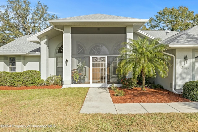 doorway to property with a lawn