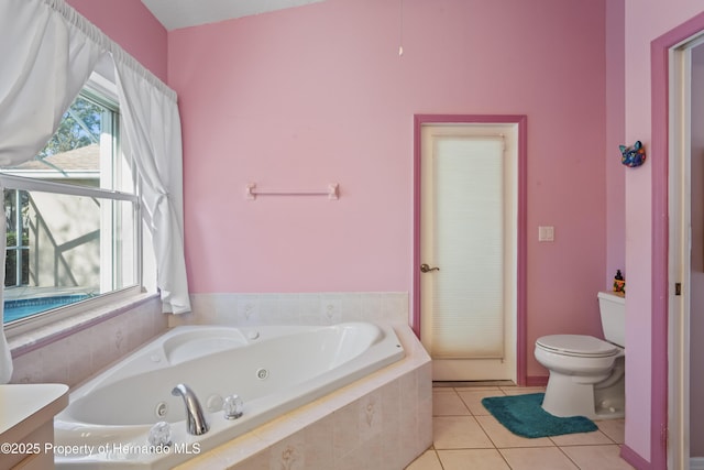 bathroom featuring vanity, tile patterned flooring, a relaxing tiled tub, and toilet