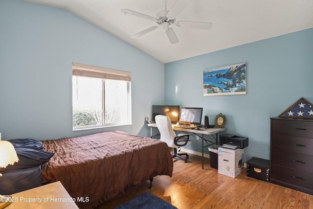 bedroom with ceiling fan, light hardwood / wood-style floors, and vaulted ceiling