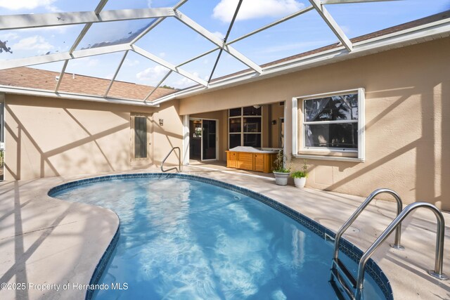 view of swimming pool featuring a lanai, a patio area, and a hot tub