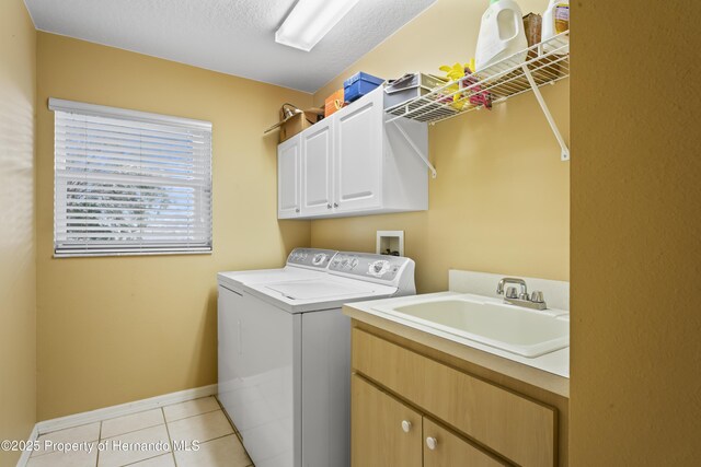 laundry room featuring cabinets, sink, independent washer and dryer, a textured ceiling, and light tile patterned flooring