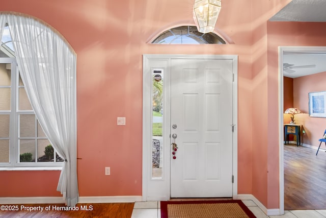 tiled foyer featuring ceiling fan