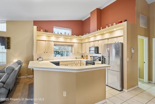 kitchen with high vaulted ceiling, black appliances, sink, light tile patterned flooring, and kitchen peninsula