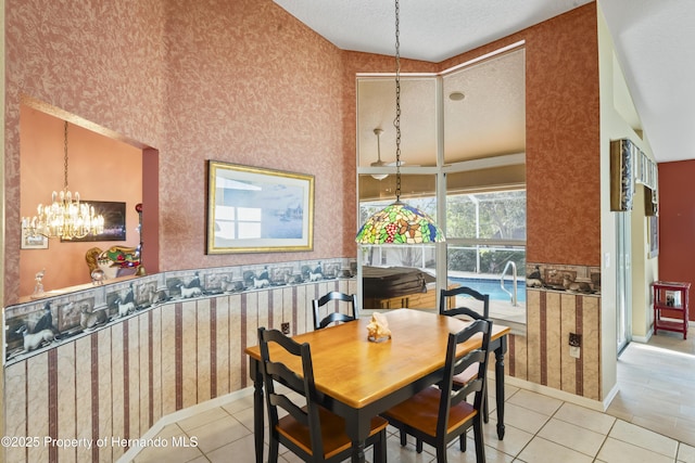 dining space with light tile patterned floors, a textured ceiling, an inviting chandelier, and lofted ceiling