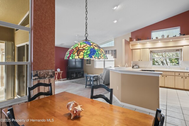 tiled dining area with sink and vaulted ceiling