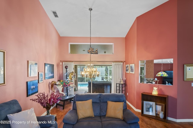 living room with an inviting chandelier, high vaulted ceiling, and hardwood / wood-style flooring