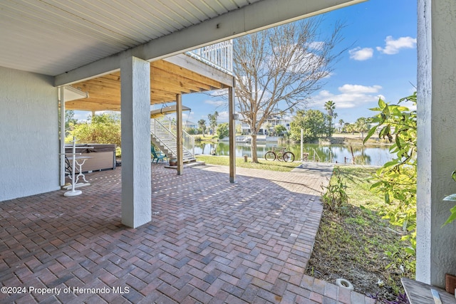 view of patio / terrace with a water view and a hot tub