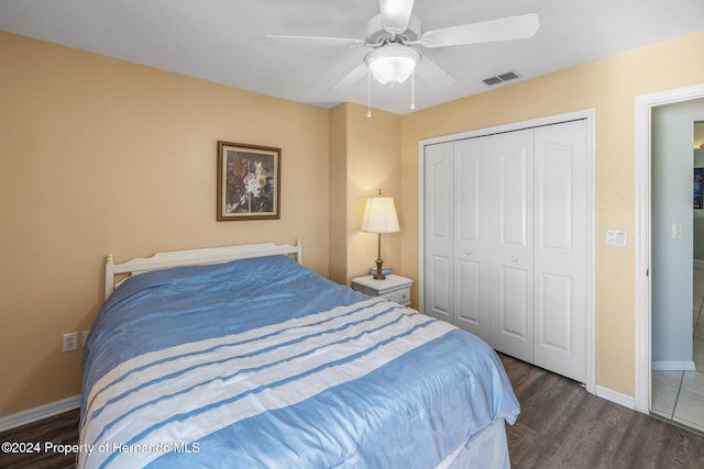 bedroom with ceiling fan, dark wood-type flooring, and a closet