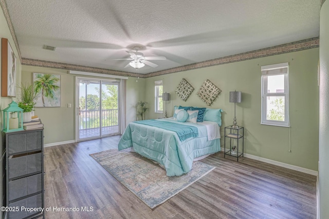bedroom with visible vents, access to exterior, wood finished floors, and baseboards