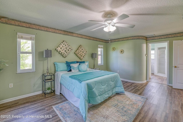 bedroom featuring a textured ceiling, wood finished floors, ceiling fan, and baseboards