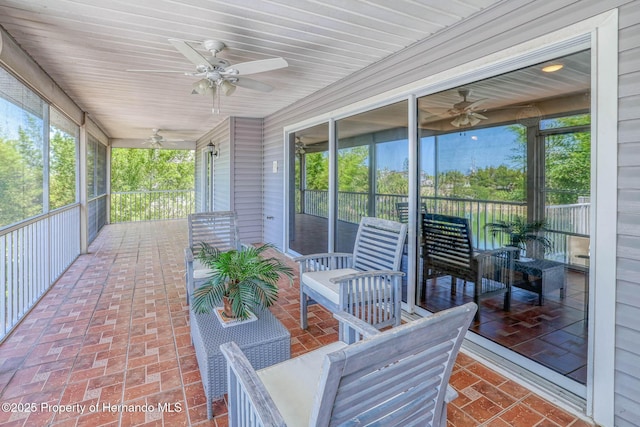 sunroom / solarium featuring ceiling fan
