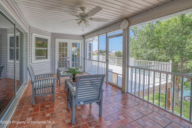 sunroom / solarium with french doors and a ceiling fan