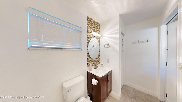 bathroom with tile patterned flooring, vanity, and toilet