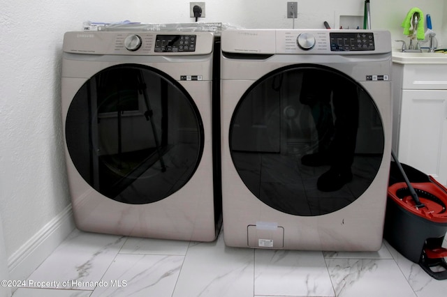 laundry area with washer and clothes dryer and cabinets