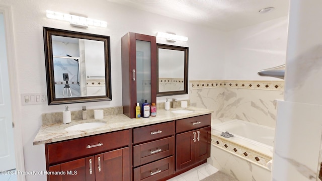 bathroom featuring vanity, a relaxing tiled tub, and tile walls