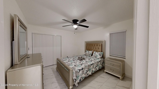 bedroom with ceiling fan and a textured ceiling