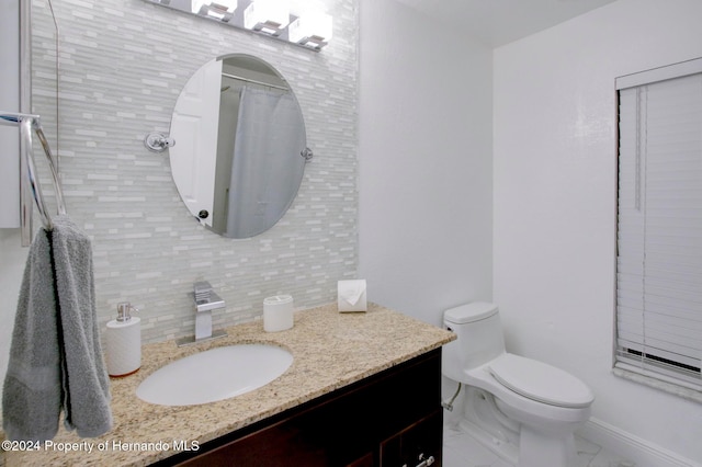 bathroom featuring vanity, toilet, tile walls, and backsplash