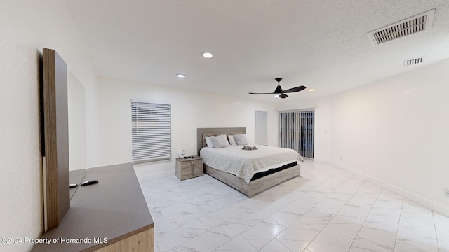 bedroom featuring ceiling fan and a textured ceiling