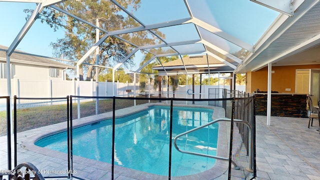 view of swimming pool featuring glass enclosure and a patio area