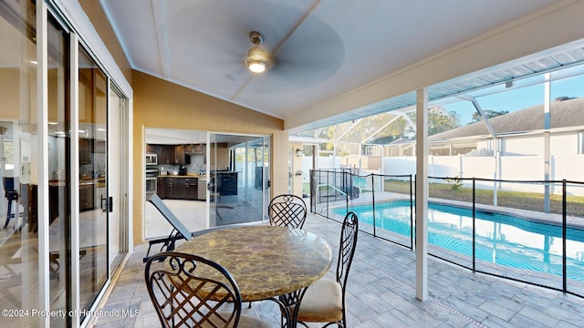 sunroom / solarium with ceiling fan and lofted ceiling