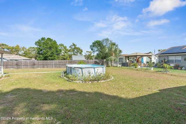 view of yard featuring a fenced in pool and a gazebo