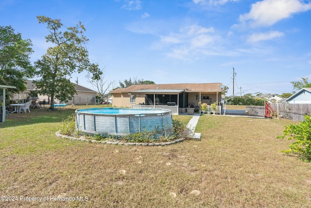 view of swimming pool with a yard and a sunroom