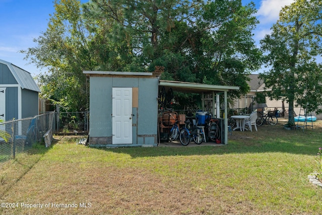 view of outbuilding featuring a lawn