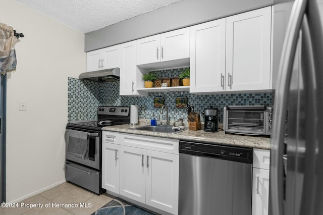 kitchen featuring sink, light tile patterned floors, white cabinetry, stainless steel appliances, and decorative backsplash