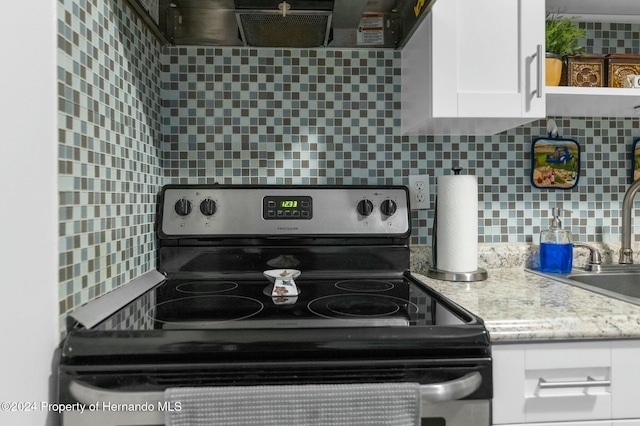 kitchen with stainless steel range with electric stovetop, white cabinetry, and tasteful backsplash