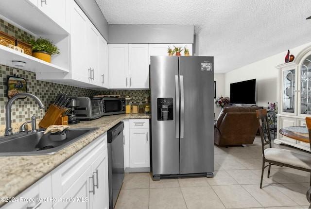 kitchen with dishwashing machine, sink, white cabinetry, and stainless steel refrigerator with ice dispenser