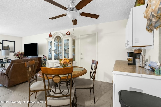 dining space with ceiling fan, a textured ceiling, and light tile patterned flooring