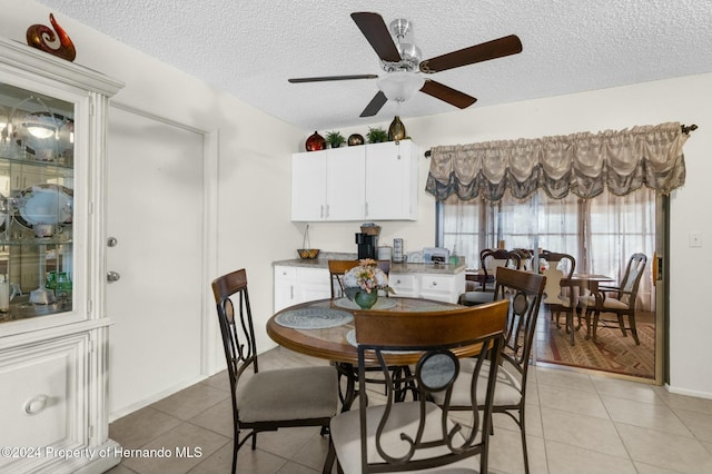 dining space with light tile patterned floors, a textured ceiling, and ceiling fan