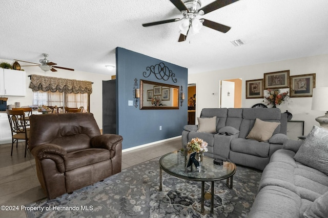 tiled living room featuring ceiling fan and a textured ceiling