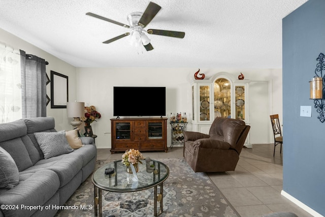 tiled living room featuring ceiling fan and a textured ceiling