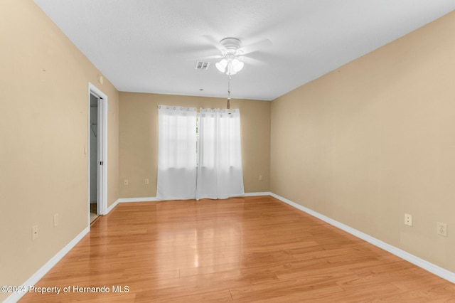 empty room with ceiling fan and light hardwood / wood-style floors