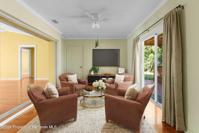 living room featuring light hardwood / wood-style flooring, ceiling fan, and ornamental molding