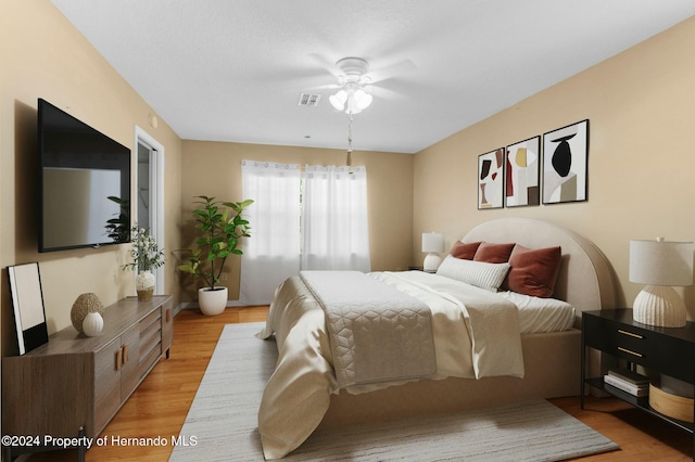 bedroom with light hardwood / wood-style floors and ceiling fan