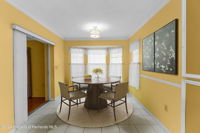 dining room with light tile patterned floors and crown molding