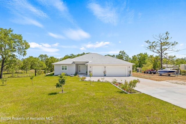 view of front of property with a garage and a front lawn