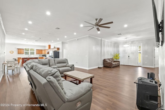 living room featuring ceiling fan, wood-type flooring, and crown molding