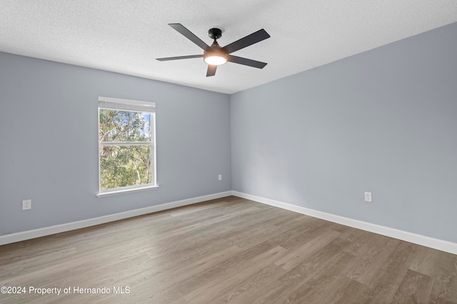 spare room with ceiling fan, a textured ceiling, and light wood-type flooring