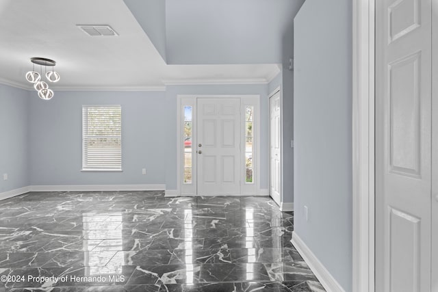 foyer entrance featuring crown molding and a healthy amount of sunlight