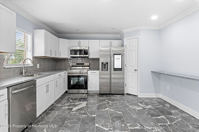 kitchen with white cabinets, backsplash, sink, and appliances with stainless steel finishes