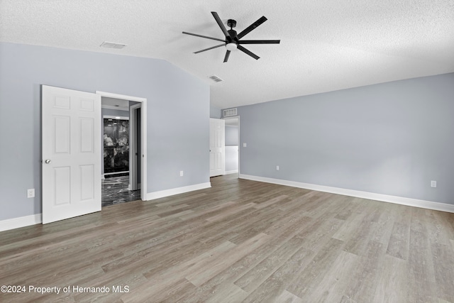 interior space featuring vaulted ceiling, ceiling fan, a textured ceiling, and hardwood / wood-style flooring