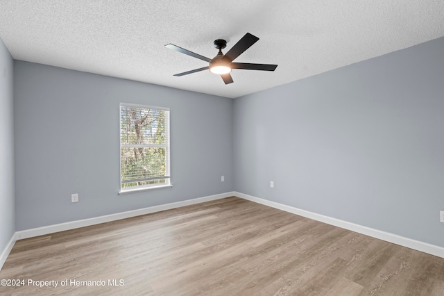 spare room with ceiling fan, light hardwood / wood-style flooring, and a textured ceiling