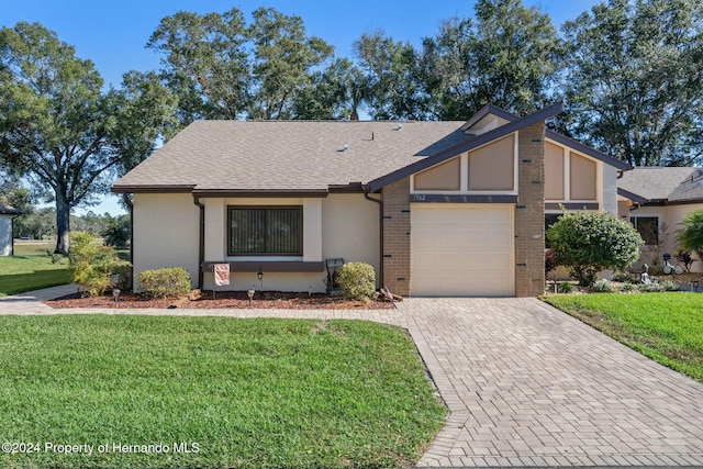 view of front of house featuring a garage and a front lawn